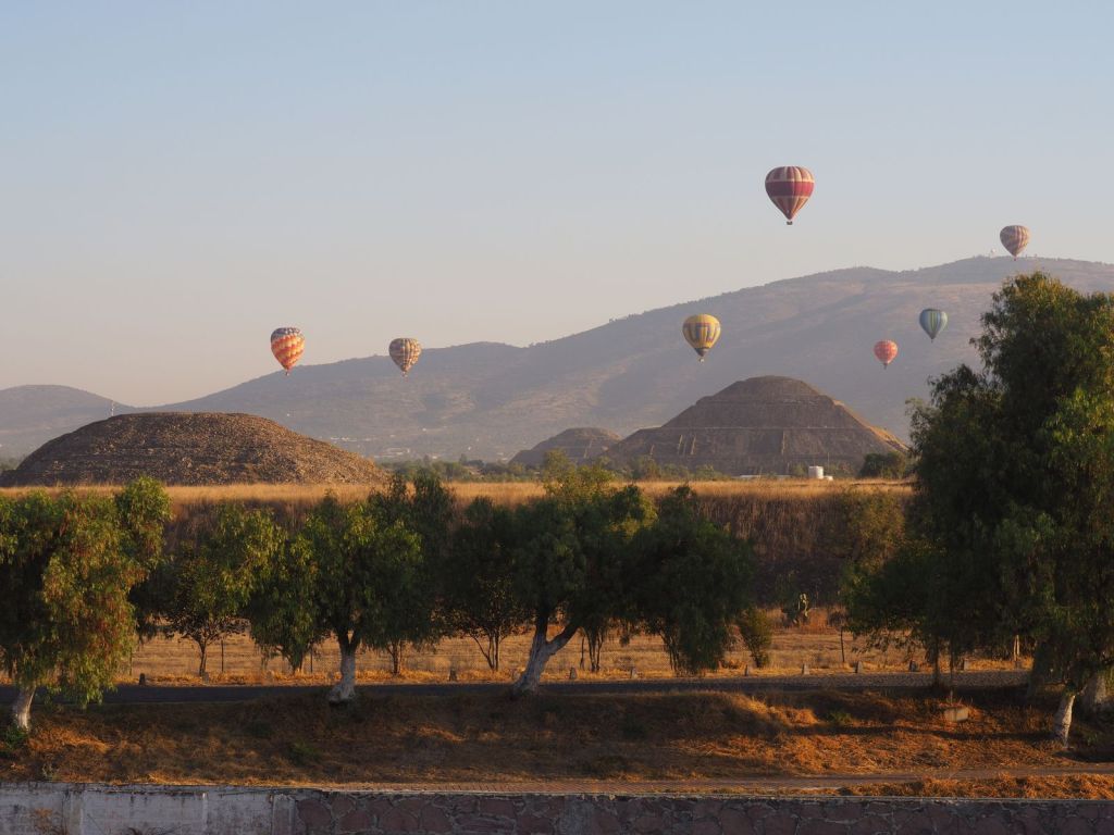 Hot air balloons floating over the pyramids on the morning of a day exploring Teotihuacan